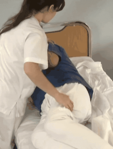 Caregiver changing a bed with PeelAways sheets